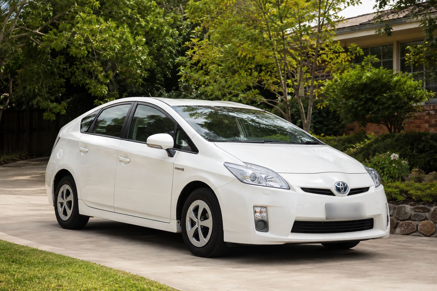 2012 Toyota Prius hybrid in a leafy suburban driveway