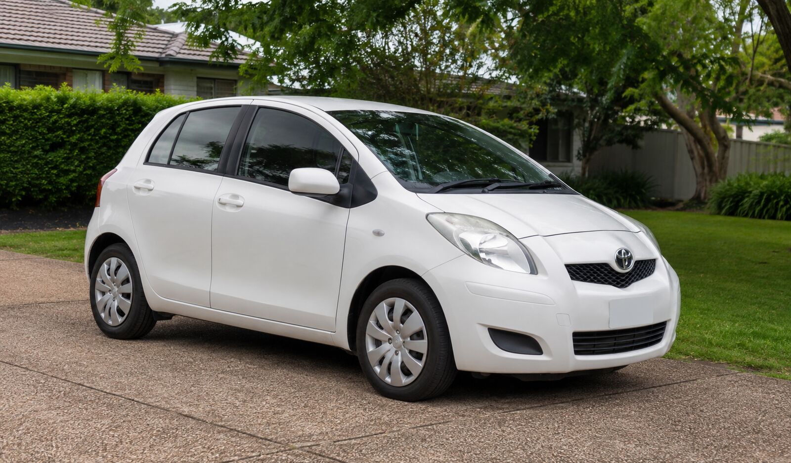2010 Toyota Yaris hatchback in a leafy suburban driveway